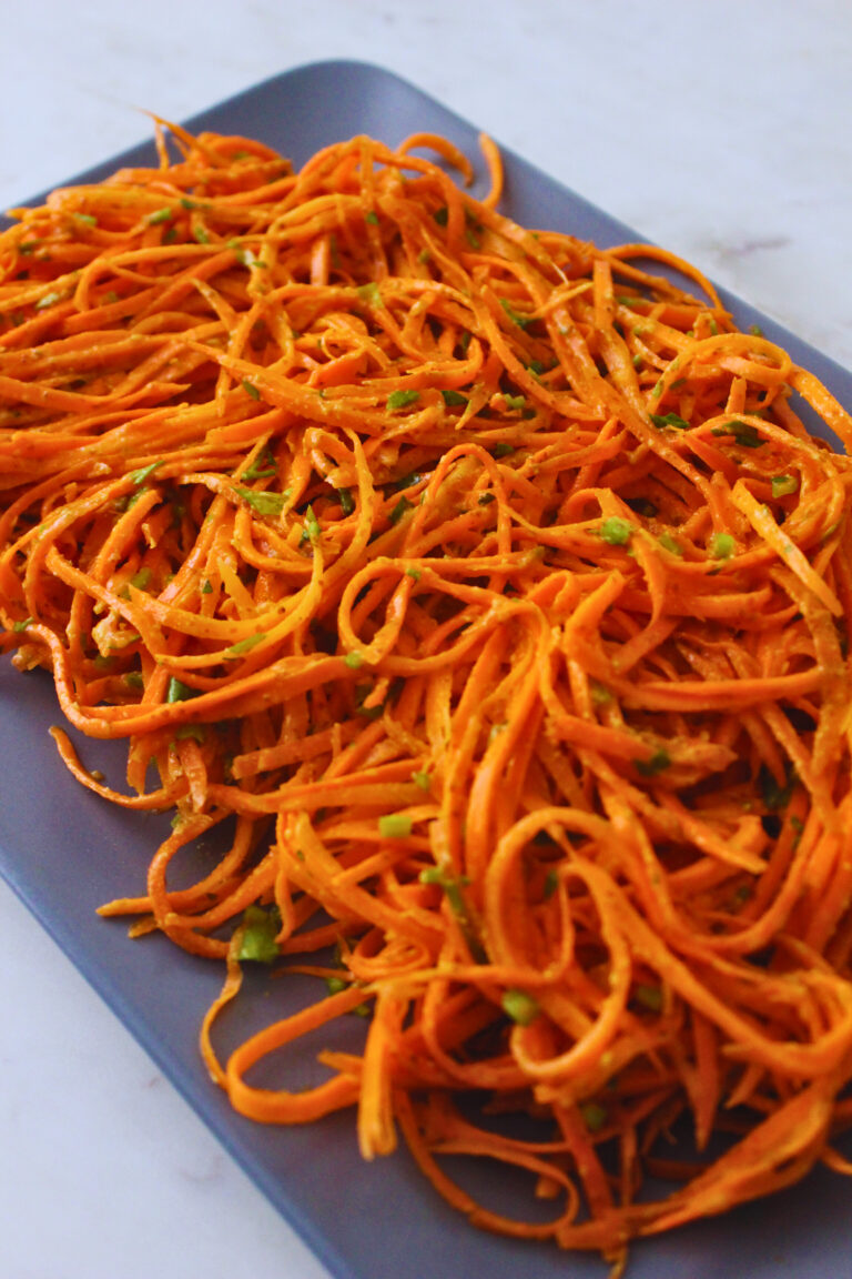 french carrot salad served on a plate topped with fresh parsley